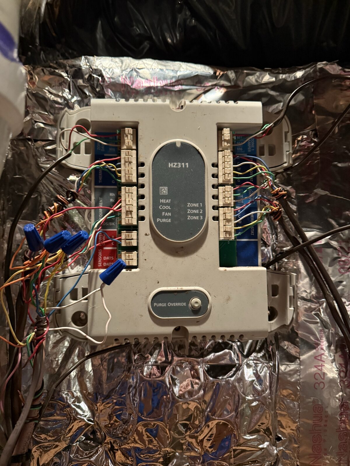 Wall-mounted zone-control board with neatly color-coded low-voltage thermostat wiring