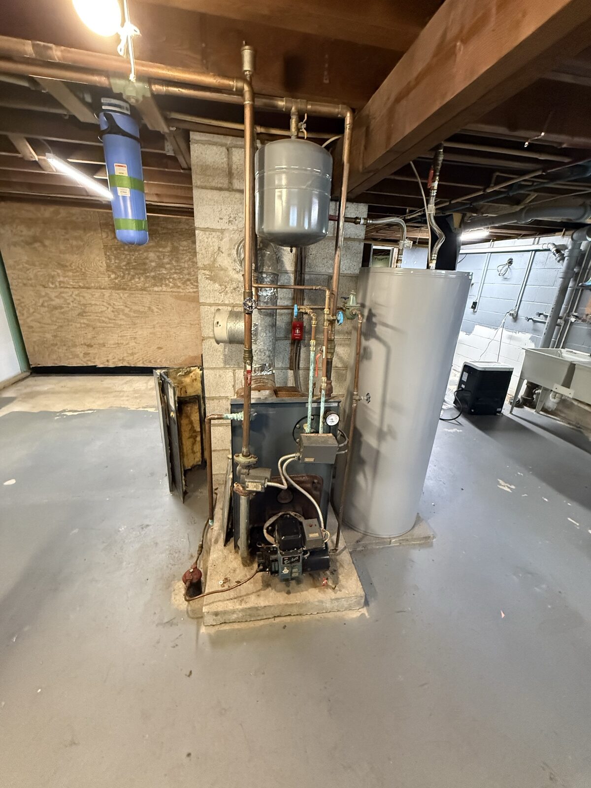Basement mechanical room with a boiler, storage tank and copper piping