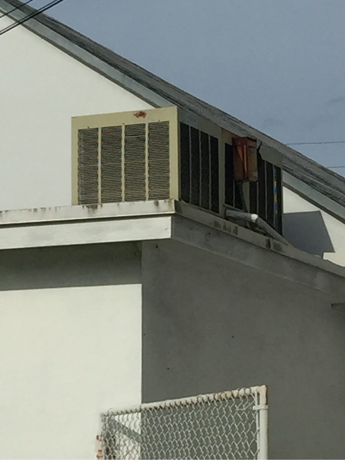 Gable attic vent louver set into the stucco exterior of a house